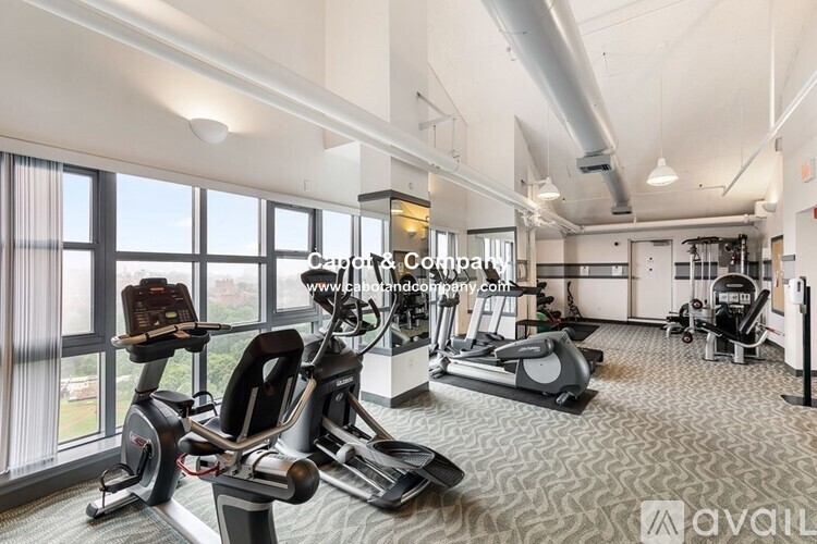 A gym with treadmills, elliptical machines, and a yoga mat.