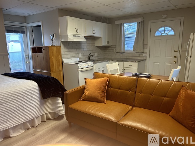 A kitchen with a couch and a bed in a room.