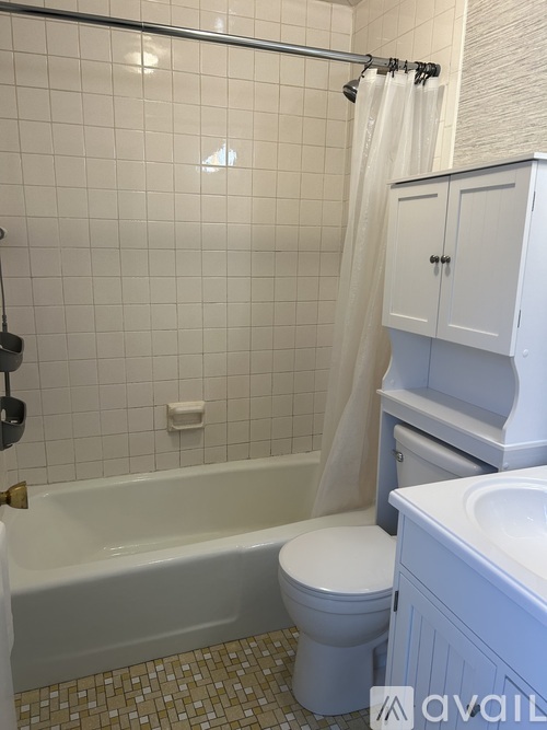 A white bathroom with a tub, toilet and sink.
