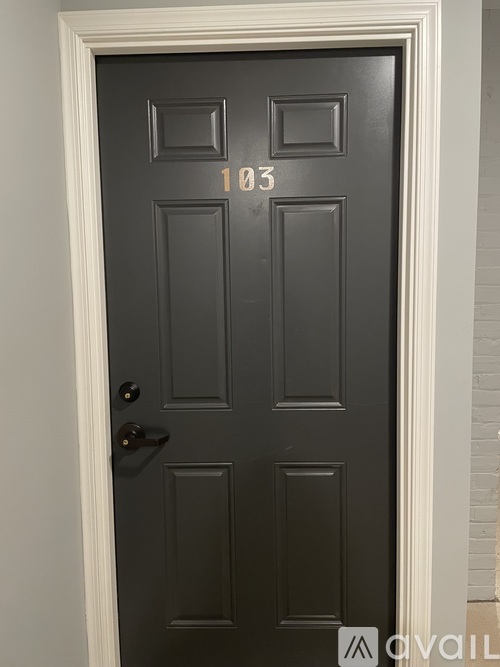 A black door with the number 103 on it.