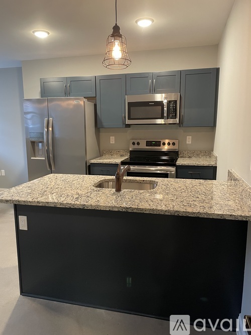 A kitchen with a granite countertop and stainless steel appliances.
