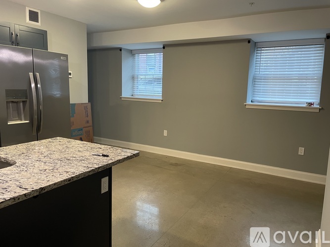 A kitchen with a granite countertop and a refrigerator.