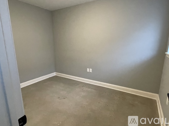 A room with a grey wall and a concrete floor.