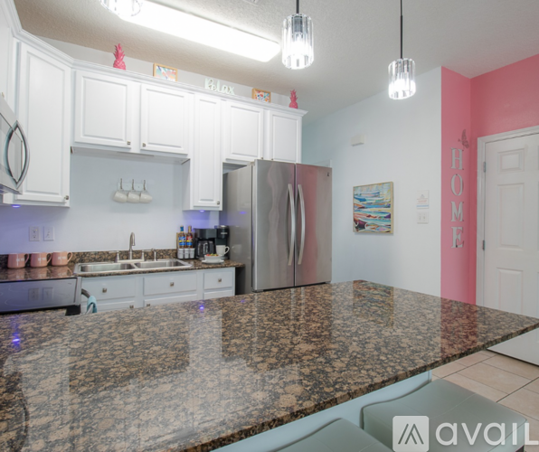 A kitchen with granite countertops and white cabinets.