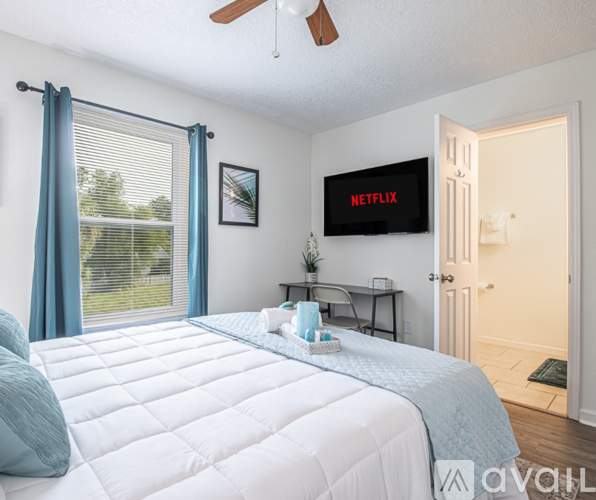 A bedroom with a large bed and a flat screen TV mounted on the wall.