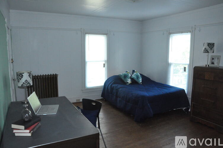 A room with a bed, a desk, and a chair.
