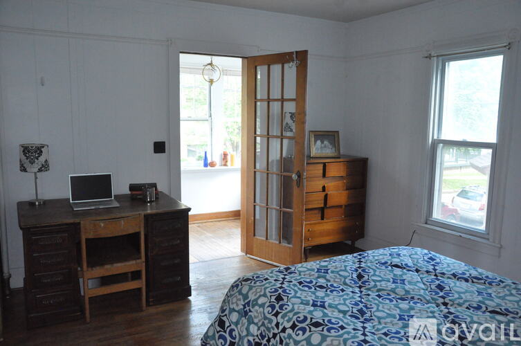 A bedroom with a bed, desk, and chair.