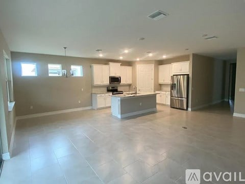 A spacious kitchen with white cabinets and a central island.