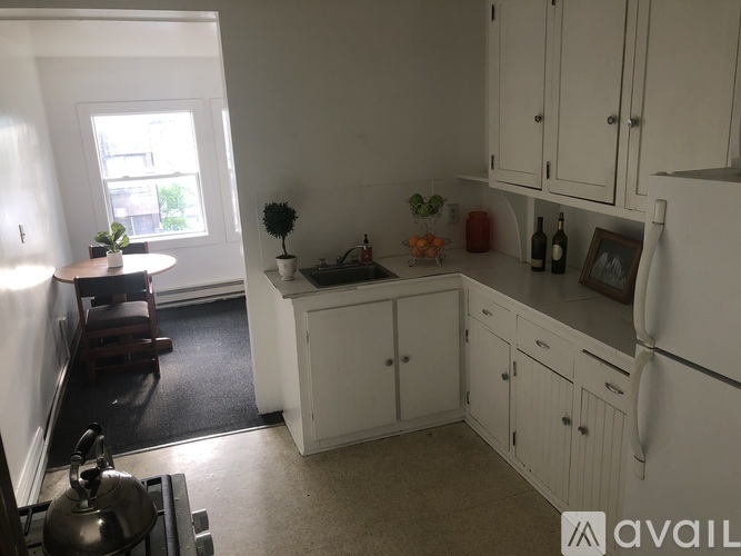 A kitchen with white cabinets and a window.