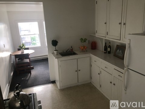 A kitchen with white cabinets and a window.