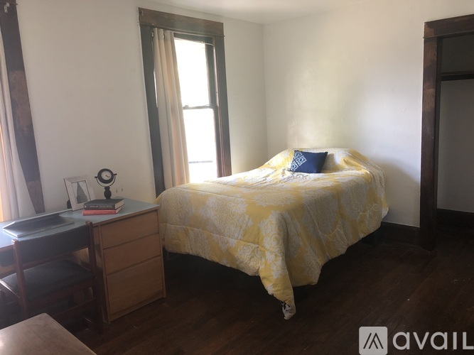 A bedroom with a bed, nightstand, and chair.