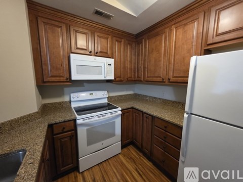 A kitchen with wooden cabinets and a white refrigerator.