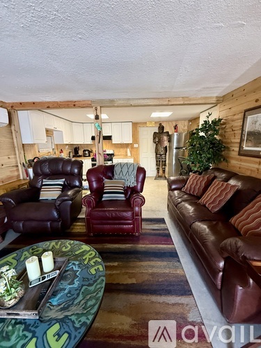 A living room with a couch, chairs, and a coffee table.
