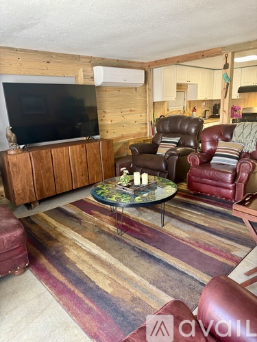 A living room with a wooden wall and a flat screen TV.