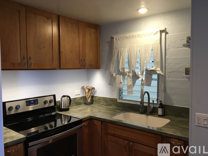 A kitchen with wooden cabinets and a black stove top oven.