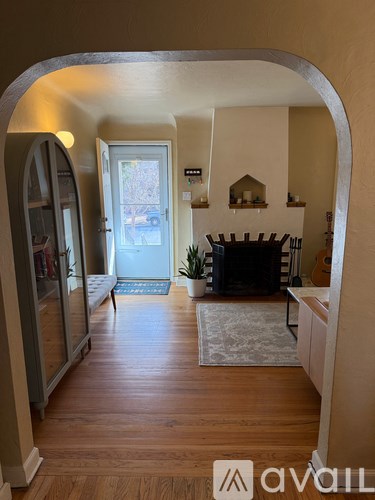 A living room with a fireplace and a rug on the floor.