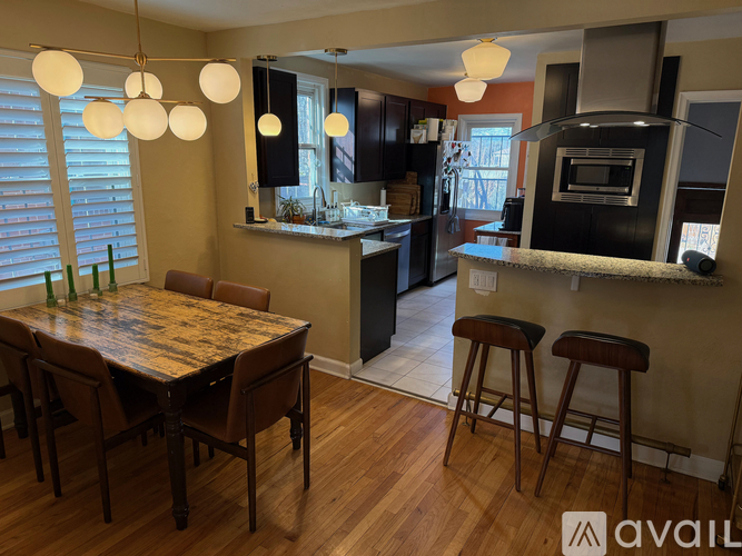 A kitchen with a table and chairs in the foreground and a bar area in the background.