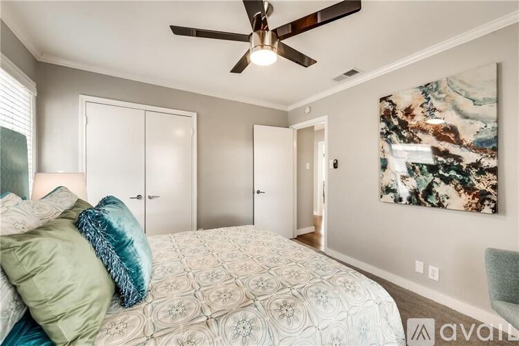 A bedroom with a large bed and a ceiling fan.