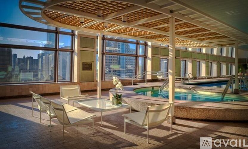 A modern outdoor patio with a pool and chairs.