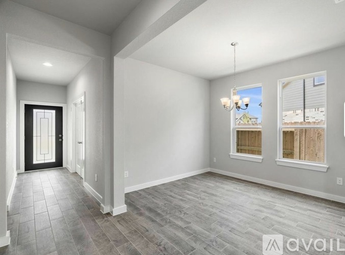 A spacious room with a tiled floor and a view of the outside through the windows.