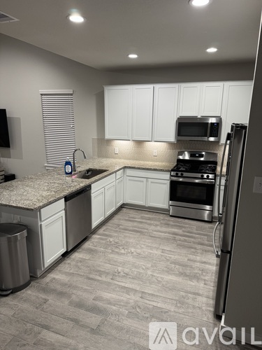 A kitchen with white cabinets and a granite countertop.