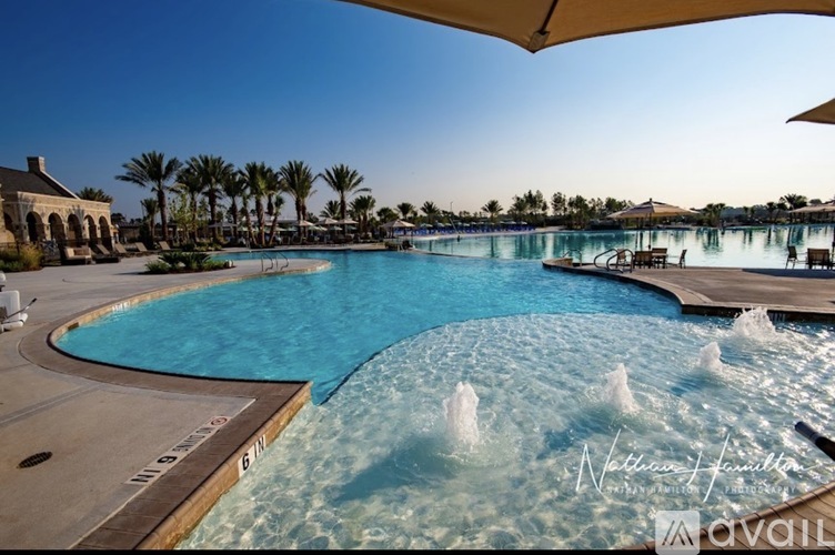 A large outdoor pool with a fountain in the middle.