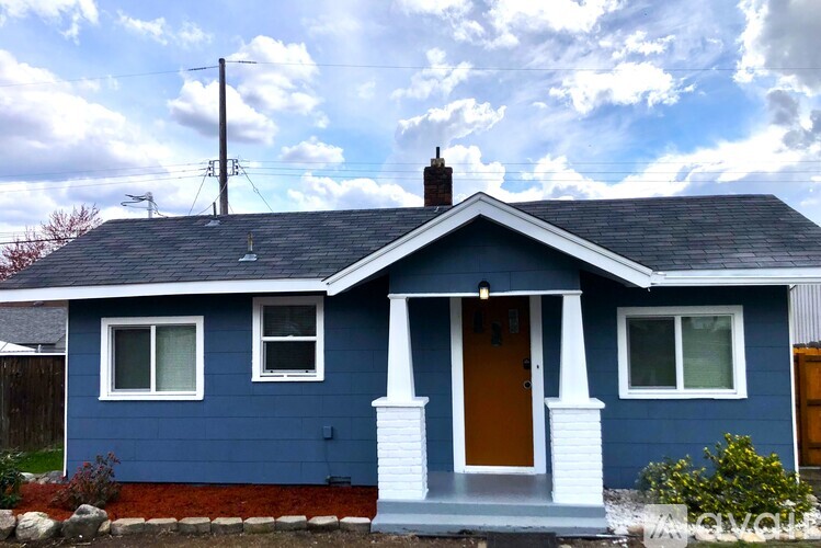 A blue house with a brown door and white trim.