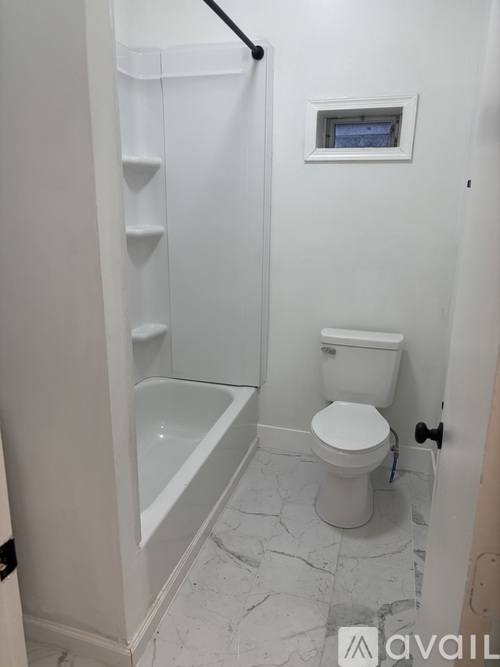 A white toilet in a bathroom with a white bathtub and a white shower.