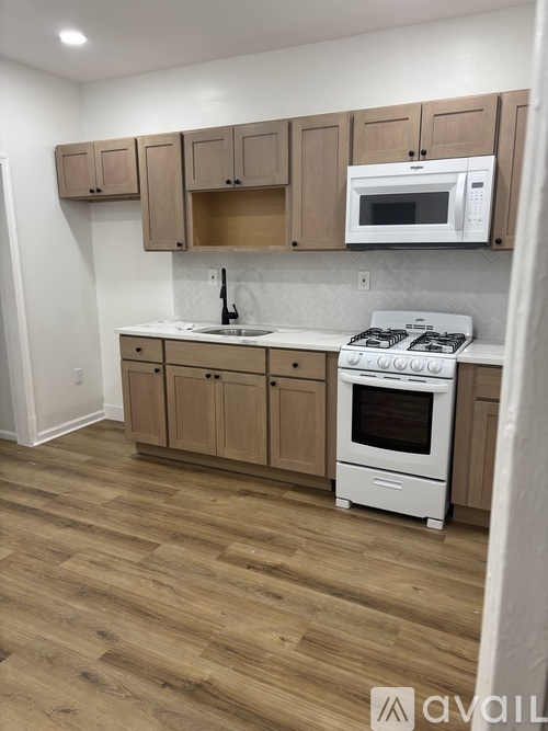 A kitchen with wooden floors and white appliances.