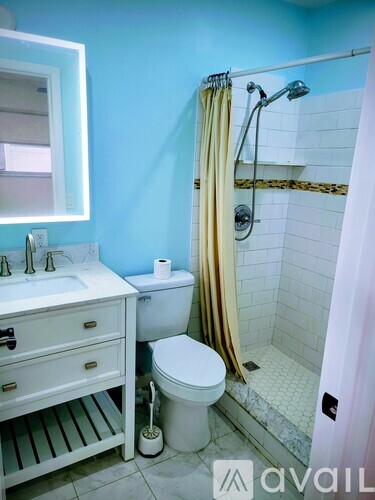 A bathroom with blue walls has a white sink and toilet.