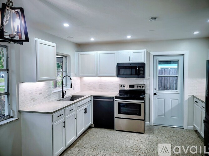 A kitchen with white cabinets and a black oven.