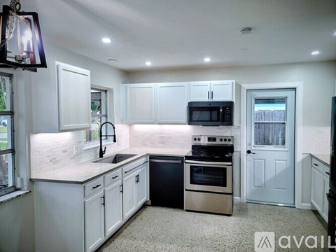 A kitchen with white cabinets and a black oven.