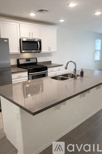 A kitchen with a granite countertop and stainless steel appliances.