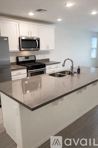 A kitchen with a granite countertop and stainless steel appliances.