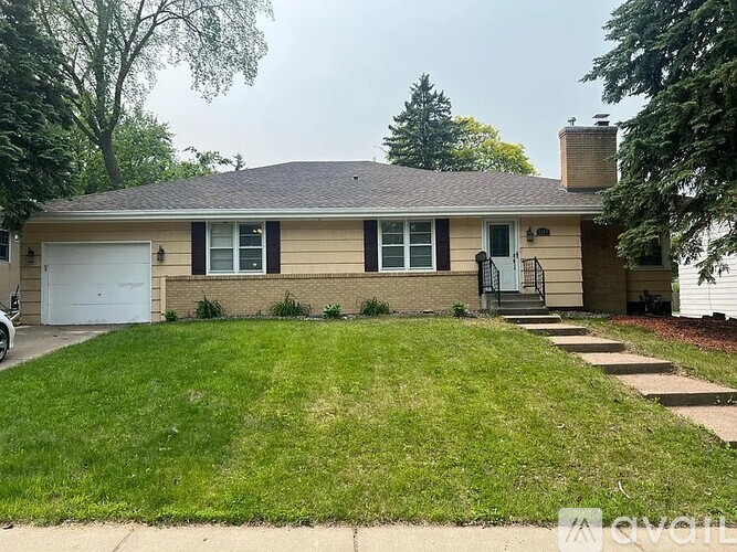 A house with a white garage door and a brown roof.