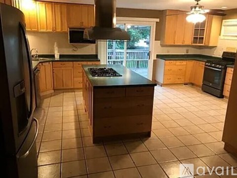 A kitchen with wooden cabinets and a black stove top.