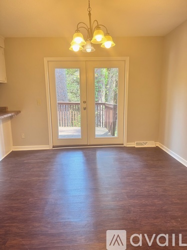 A room with wooden floors and a chandelier.