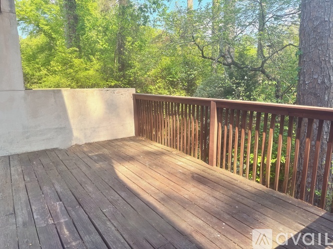 A wooden deck overlooks a forest.