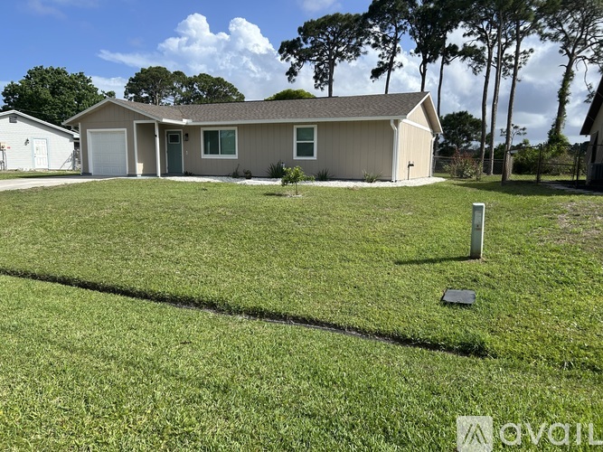 A house with a green lawn in front of it.
