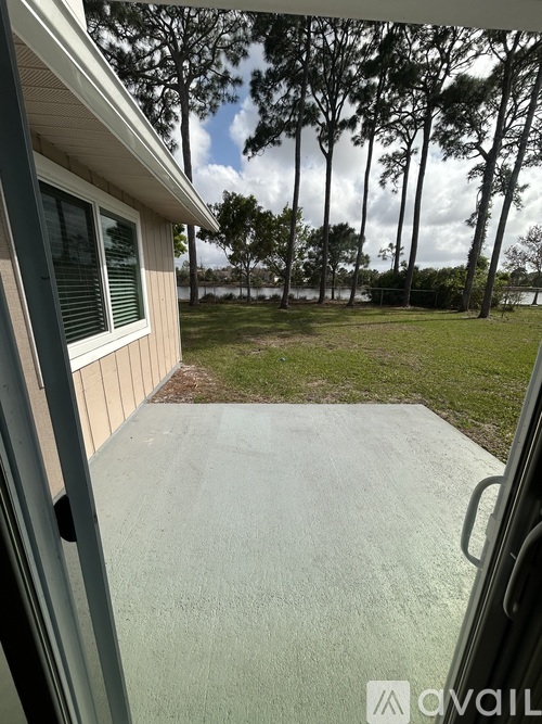 A view from a window looking out to a grassy area with trees.
