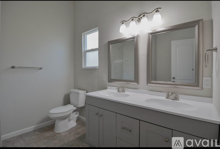 A bathroom with a toilet, sink, and mirror.