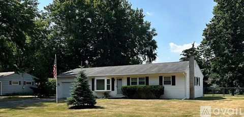 A house with a flag on the front lawn.
