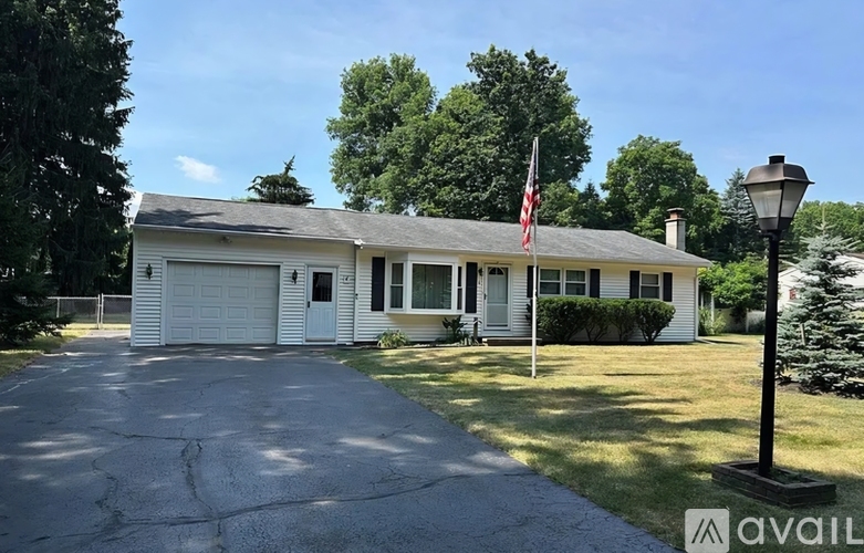 A house with a flag on the front and a lamp post to the right.