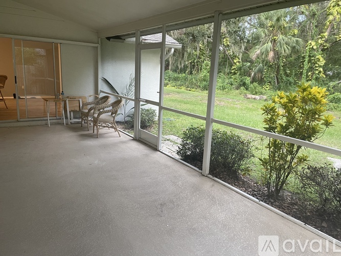 A patio with a table and chairs overlooks a garden.