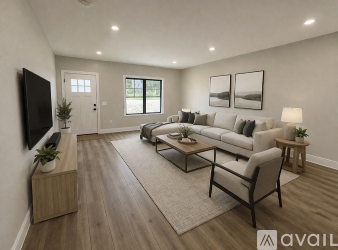 A modern living room with a large couch, a flat-screen TV, and a coffee table.