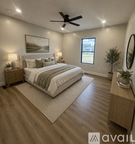 A bedroom with a large bed, a ceiling fan, and a window.