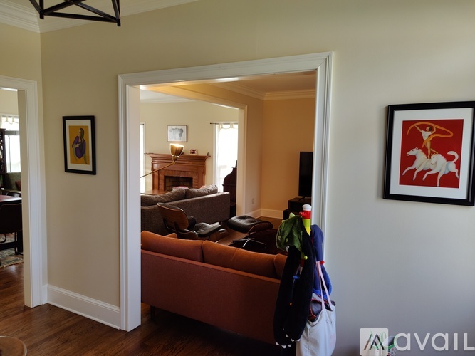 A living room with a brown couch and a painting on the wall.