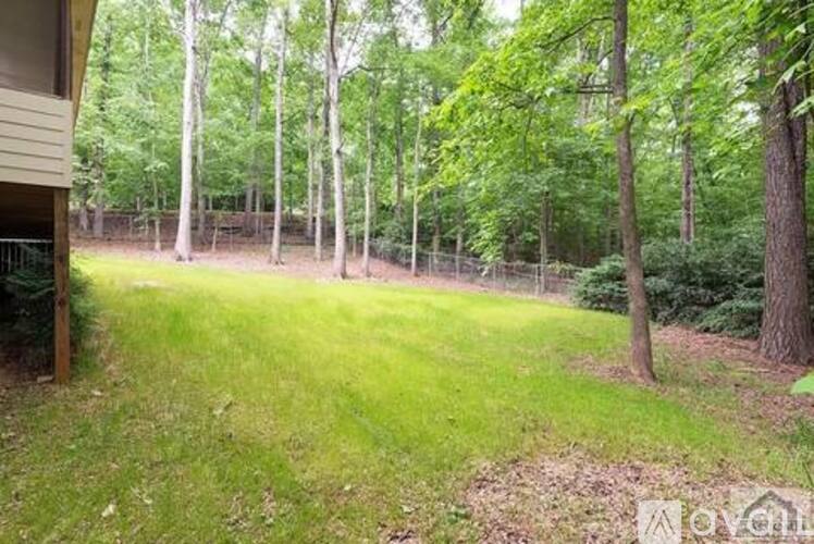 A backyard with a fence and trees.