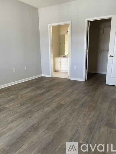 A room with wooden flooring and two open doors.