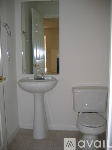 A white pedestal sink and toilet in a bathroom.